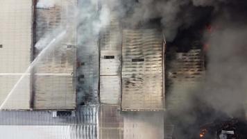 vista aérea mangueira de fogo spray de água na queima acontece na fábrica video