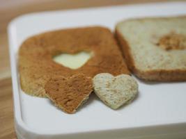 pareja en forma de corazón en pan integral puesto en bandeja blanca, fondo amor día de san valentín foto