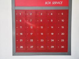 post office mailbox box service screen white text number one to thirty on front red steel with key Mortise lock, strack in the row photo