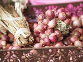 Small onion in a bunch, placed in a brown plastic basket photo