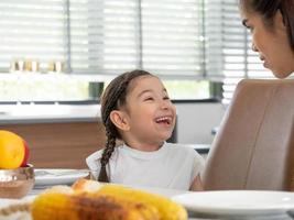 Candid close up face eye portrait pretty Baby kid girl happy talk laugh funny enjoy smile and mom hug mother female person holiday lifestyle family day parent indoor living room kitchen eat breakfast photo