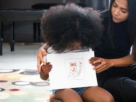 Child girl son person creative idea drawing art picture family mother young adult education fun enjoy show paper happy smile black african person indoor home house paint together love activity photo