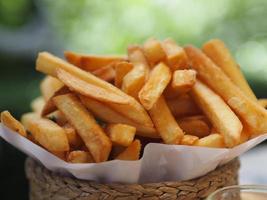 papas fritas, papas fritas papas fritas crujientes amarillas en una canasta de madera, bocadillos deliciosos foto