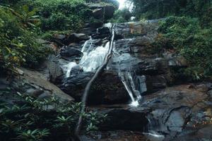 Waterfall in the tropical forest in the rainy season photo