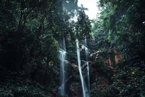 Waterfall in the tropical forest in the rainy season photo