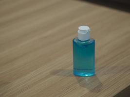 desinfectante de manos, mezcla de gel alcohólico con gelatina en botella de plástico transparente con bomba que empuja el lavado limpio y sucio para evitar que los gérmenes protejan la enfermedad contagiosa coronavirus covid-19, en un escritorio de madera foto