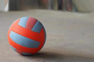 volley ball placed on the concrete ground, blue and orange color, sport photo