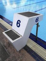 la ola de agua azul en la piscina se refleja con la luz del sol, la cerámica azul para la carrera de natación y los deportes acuáticos foto