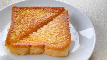 Two piece triangle slices of toasted bread made from white wheat flour and a slice of cheddar cheese in white plate. photo