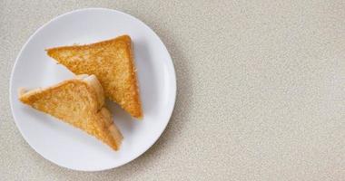 Two piece triangle slices of toasted bread made from white wheat flour and a slice of cheddar cheese in white plate. photo