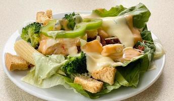 Fresh vegetable salad plate on table background photo