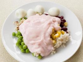 Assorted nuts and quail eggs topped with strawberry yogurt white dish photo
