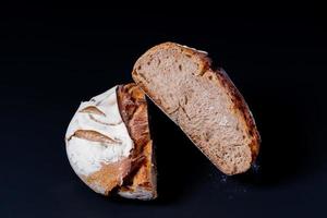 Fresh sourdough bread with a coffee mug on black background. photo