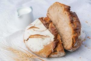 Fresh sourdough bread with a coffee mug on white fabric. photo