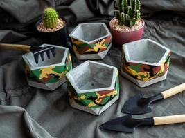 Pentagon concrete planters with camouflage pattern painting. Painted concrete pots for home decorations photo