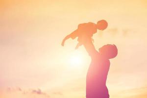 Father took the baby learn to walk at sunset. photo