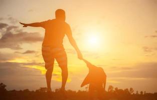 Happy dad throws the baby at sunset photo