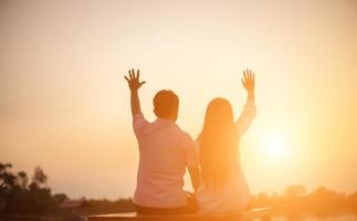 a silhouette of a man and woman holding hands with each other, walking together. photo