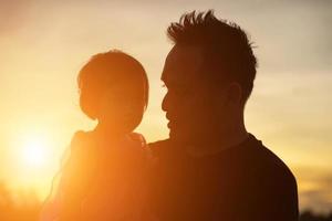 el padre llevó al bebé a aprender a caminar al atardecer. foto