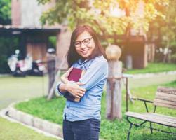 Hipster charming girl relaxing in the park while read book, Enjoy nature around. photo