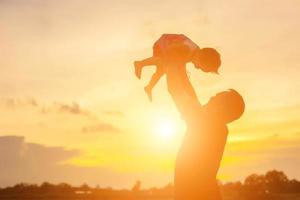 Father took the baby learn to walk at sunset. photo