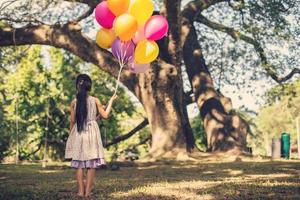 niña con globos en un campo foto