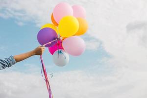 Beautiful Girl jumping with balloons on the beach photo