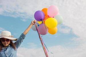 Beautiful Girl jumping with balloons on the beach photo