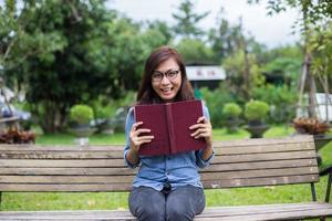 A woman sitting in the garden reading a book. photo