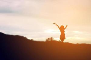 Silhouette of woman praying over beautiful sky background photo