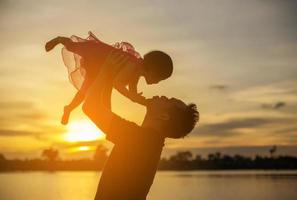 el padre llevó al bebé a aprender a caminar al atardecer. foto