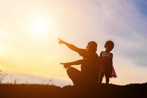 Father took the baby learn to walk at sunset. photo