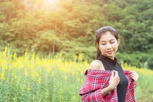 joven hermosa mujer de pie en el disfrute del campo de flores. foto