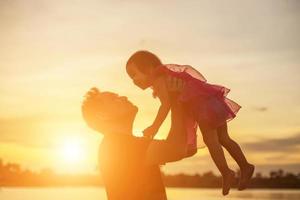 Father took the baby learn to walk at sunset. photo