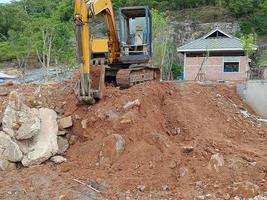 Crawler excavator front view digging on demolition site stop working or taking a break photo