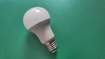 White light bulb on colored background in pastel colors. Minimalist concept, bright idea concept, isolated lamp