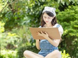 Asian girl drawing and smiling happily in the park. Happy Holiday Outdoor Living concept photo