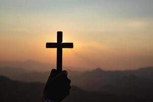 silhouette hand holding cross photo