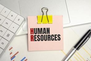 human resources word on sticker on notepad with pen and calculator