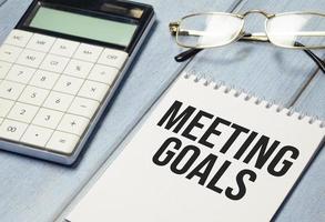 pen and a sheet of white paper with the text MEETING GOALS photo