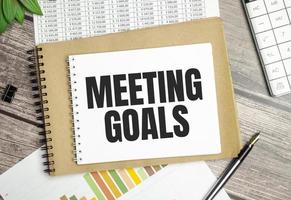 Paper with text MEETING GOALS on the table on the chart photo