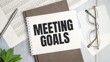 Paper with text MEETING GOALS on the table on the chart photo