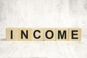 income word, text written on wooden cubes photo