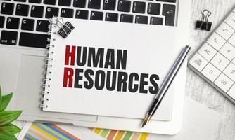 human resources . text on white paper and laptop on wooden background photo