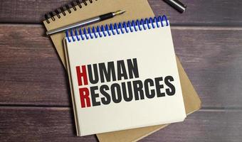 notebook with the word human resources on wooden background photo