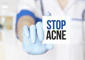 Doctor writing word stop Acne on sticker, Medical concept photo