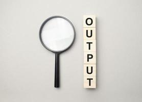 the wooden cubes with the word output and magnifier photo