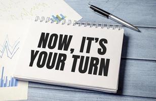 pen and a sheet of white paper with the text NOW ITS YOUR TURN photo