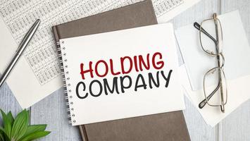 Paper with text HOLDING COMPANY on the table on the chart photo
