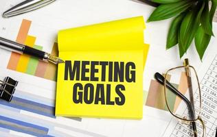 yellow sticker with the text MEETING GOALS and charts photo